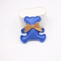 Detailed close-up of a blue faux leather bear charm with fine stitching and a brown bow - Sapphire Blue