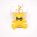 Close-up of yellow leather bear charm with plaid bow and gold metal keychain - Bear Charm / Yellow
