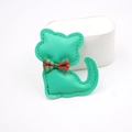 Detalle del colgante de gato en cuero verde con lazo de cuadros rojos y verdes y costuras - Verde