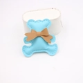 Detail view of light blue leather bear charm with brown bow and white stitching - Light Blue