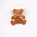 Detail of brown faux leather bear charm featuring stitched edges and a cute bow tie - Coffee