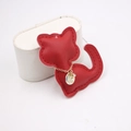 Detail of red cat leather charm with gold chain and rhinestone tag on white stand - Red