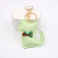 Dettaglio di un portachiavi a gatto in pelle verde chiaro con cuciture bianche e fiocco - Verde matcha