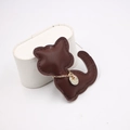 Dark brown leather cat-shaped pendant with a gold chain and metal tag for accessories - Brown