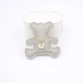 Close-up of golden necklace with a round engraved pendant and a tiny diamond decoration - Gray