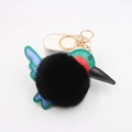 Detail of plush hummingbird keychain with green and blue faux leather wings and gold clasp - Black