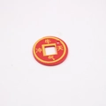 Macro view of a red Chinese coin pendant with gold lettering on a white background - Ox Power