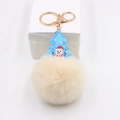 Detail of Christmas plush keychain featuring blue tree pendant and white faux fur pompom - Off-white