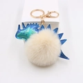 Dinosaurier-Anhänger aus Laserleder mit flauschigem Bommel und goldenem Schlüsselring - Cremeweiß