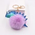 Détail d'un porte-clés dinosaure en fausse fourrure violette avec écailles irisées - Violet Taro