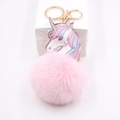 Close-up of a pink faux fur unicorn keychain with rainbow mane and golden metal clip - Light Pink