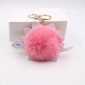 Detailed view of pink plush pom pom dinosaur keychain with iridescent leather scales and gold ring - Deep Pink