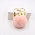 Porte-clés licorne en fausse fourrure rose avec corne dorée et fermoir sur blanc - Rose