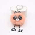 Détail d'un porte-clés raton laveur en peluche orange avec petites pattes de chat - Rose