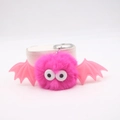 Detailed close-up of fluffy pink pom-pom bat keychain with cute wings and big eyes - Rose Red