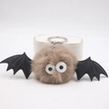 Vista macro di portachiavi peluche pipistrello di Halloween con occhi mobili e ali nere - Cachi
