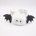 Dettaglio di un simpatico portachiavi a pipistrello in peluche bianco con ali nere - Bianco