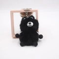 Detail view of a cute black plush bear keychain with soft texture and silver metal ring - Black
