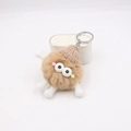 Détail du porte-clés monstre en peluche avec fourrure marron, bonnet tricoté et yeux - Khaki