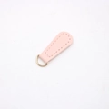 Macro detail of teardrop pink leather pendant with a gold D-ring for DIY accessories - Pink