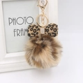 Detalle de lazo con estampado de leopardo y pompón de llavero con cierre dorado - Llavero Dorado / Caqui