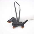 Detail view of a handcrafted black and brown leather dachshund puppy keychain with strap - Small Lanyard Style / Black