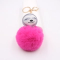 Détail du pompon en fausse fourrure rose vif et breloque paresseux sur porte-clés doré - Rose rouge