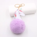Detail view of purple plush pompom unicorn keychain with gold metal ring and lobster clasp - Gold Keychain / Taro Purple