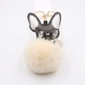 Détail d'un porte-clés chien cool avec lunettes de soleil et pompon en fourrure beige - Porte-clés Doré / Blanc Cassé