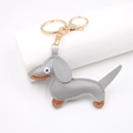 Detail showing grey leather dachshund charm with neat stitching and gold metal lobster clasp - Gray