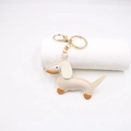 Detail of a beige leather dachshund keychain with brown accents and gold metal clasp - Off-white