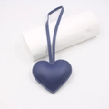 Close-up of blue heart-shaped leather bag charm with litchi grain texture and stitching - Navy Blue