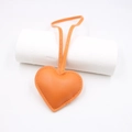 Macro detail of an orange leather heart charm with yellow stitching for bags - Orange