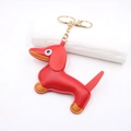 Macro detail of red leather dachshund keychain with golden ring and lobster clasp - Red