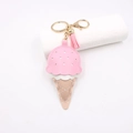 Detailed close-up of pink and white leather ice cream keychain with gold ring and tassel - Pink