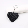 Primer plano del llavero de corazón con estampado de leopardo, felpa gris y anillo de plata - Negro