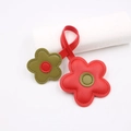 Detailansicht der Blumen-Lederanhänger mit rot-grünen Kontrastnähten und Textur - Rot