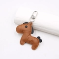 Close-up of brown pebbled leather horse keychain with heart embossing and silver clasp - Horse Shape Pendant / Brown