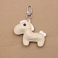 Close-up of beige leather horse charm keychain with fine stitching and silver spring clasp - Horse Shape Pendant / Beige and White Tail
