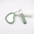 Détail du porte-clés miroir de poche en cuir vert en forme de cœur avec coutures - Cœur / Vert