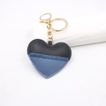 Detail van hartvormige leren sleutelhanger met stiksels en gouden metalen karabijnhaak - Blauw/Zwart