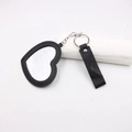 Détail du porte-clés miroir en forme de cœur avec cadre en cuir noir et anneau métal - Cœur / Noir