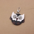 Close-up of a handmade owl leather keychain with silver rivets and metal spring clasp - Black
