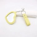 Détail du porte-clés miroir de poche en cuir jaune clair en forme de cœur avec dragonne - Cœur / Jaune