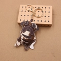 Detail of pug leather keychain with golden ring on vintage patterned gift box - Beige