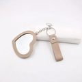 Détail du porte-clés miroir en cuir beige en forme de cœur avec anneau en métal argenté - Cœur / Khaki