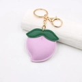 Vue détaillée du porte-clés pêche en cuir violet avec fermoir métallique doré - Style Pêche / Violet Taro