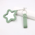Détail d'un porte-clés miroir en cuir vert sauge en forme d'étoile avec anneau métal - Pentagramme / Vert matcha