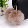 Detail of light brown faux fur double ball charm on a black leather handbag gold chain - 8cm / Khaki