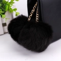 Detail of soft black faux rabbit fur double pom pom keychain with gold chain on a bag - 8cm / Black